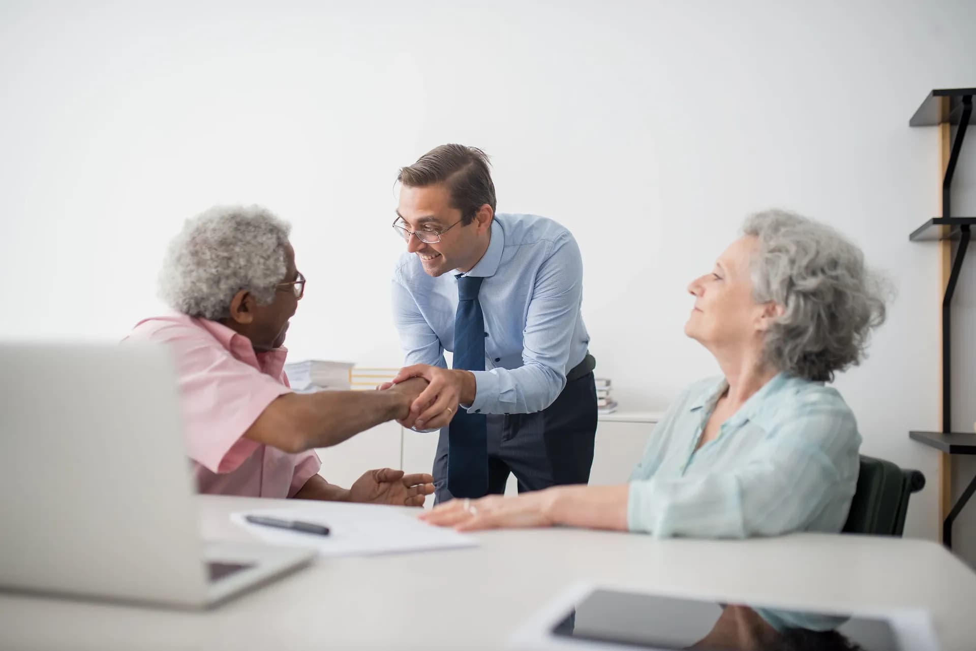 A happy old couple with an insurance advisor