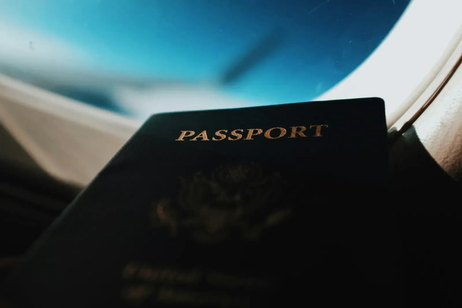 A passport held up against an aircraft window